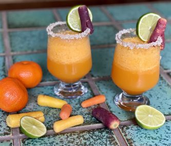 2 GEORGE’S® Carrot Margaritas served in salt rimmed glasses with lime wheels for garnish