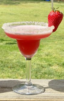 GEORGE’S® Frozen Strawberry Margarita served in salt rimmed glass with strawberry garnish