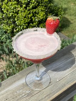 GEORGE’S® Frozen Strawberry Daiquiri served in salt rimmed glass with strawberry garnish