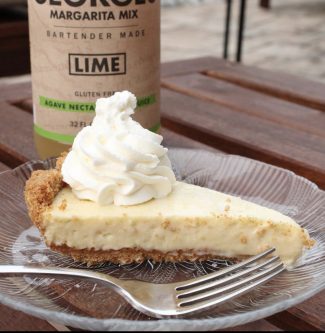 slice of GEORGE’S® Margarita Refrigerator Pie on a plate topped with whipped cream