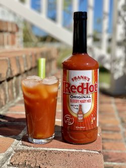 FRANK'S RedHot® Bloody Mary cocktail and bottle on brick steps