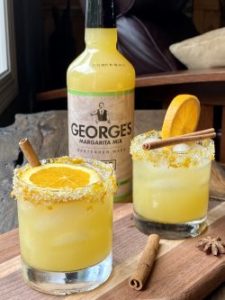 2 GEORGE’S® Spiced Orange Margaritas served with orange slices, cinnamon sticks, star anise for garnish