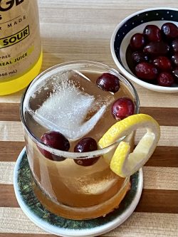GEORGE’S® Cranberry Whiskey Sour served with lemon twist garnish
