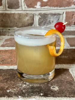 GEORGE’S® Boston Sour served with orange peel and cocktail cherry garnish