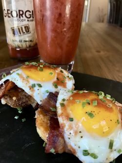 two eggs GEORGE’S® Way on plate next to bloody mary