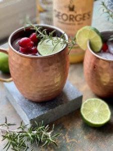 GEORGE’S® Cranberry Mules served with cranberries and rosemary sprigs garnish