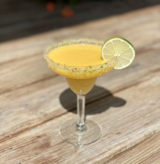 GEORGE’S® Frozen Mango Margarita served in sugar rimmed glass with lemon slice garnish