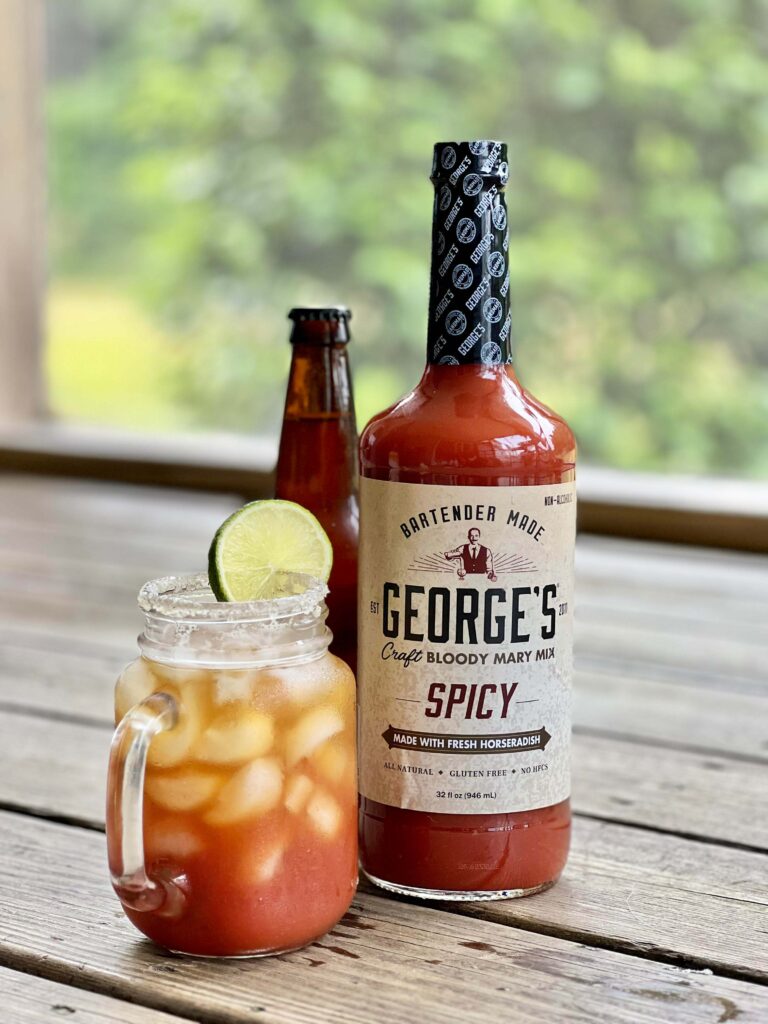 george's spicy bottle with michelada cocktail in mason jar