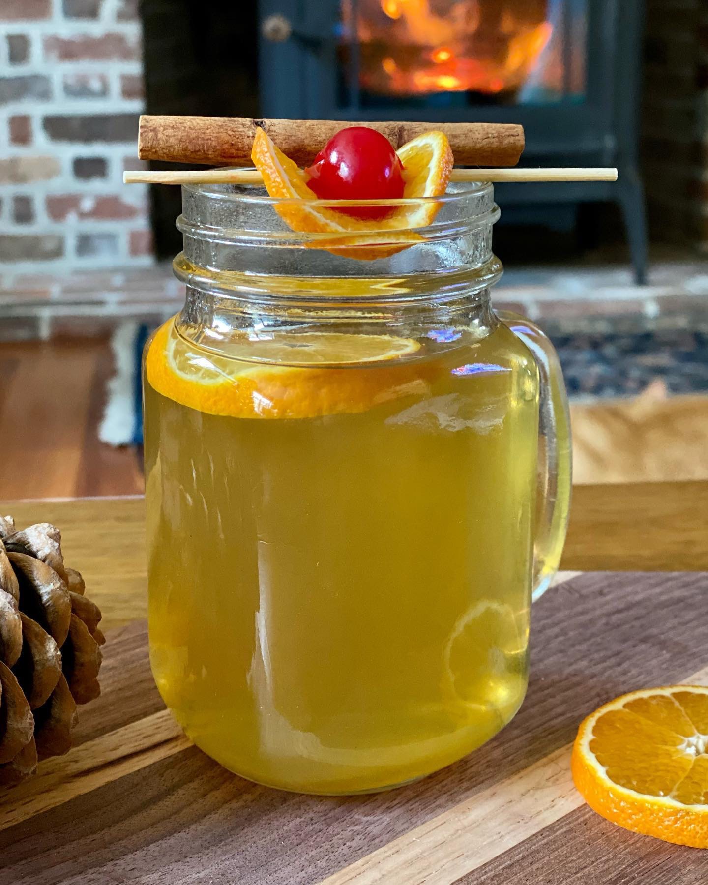 hot toddy cocktail with lemon whiskey sour mix with orange cinnamon stick and a cherry