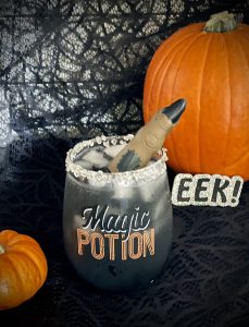 spooky wine glass with 'magic potion' on the front with a fake finger sticking out of it