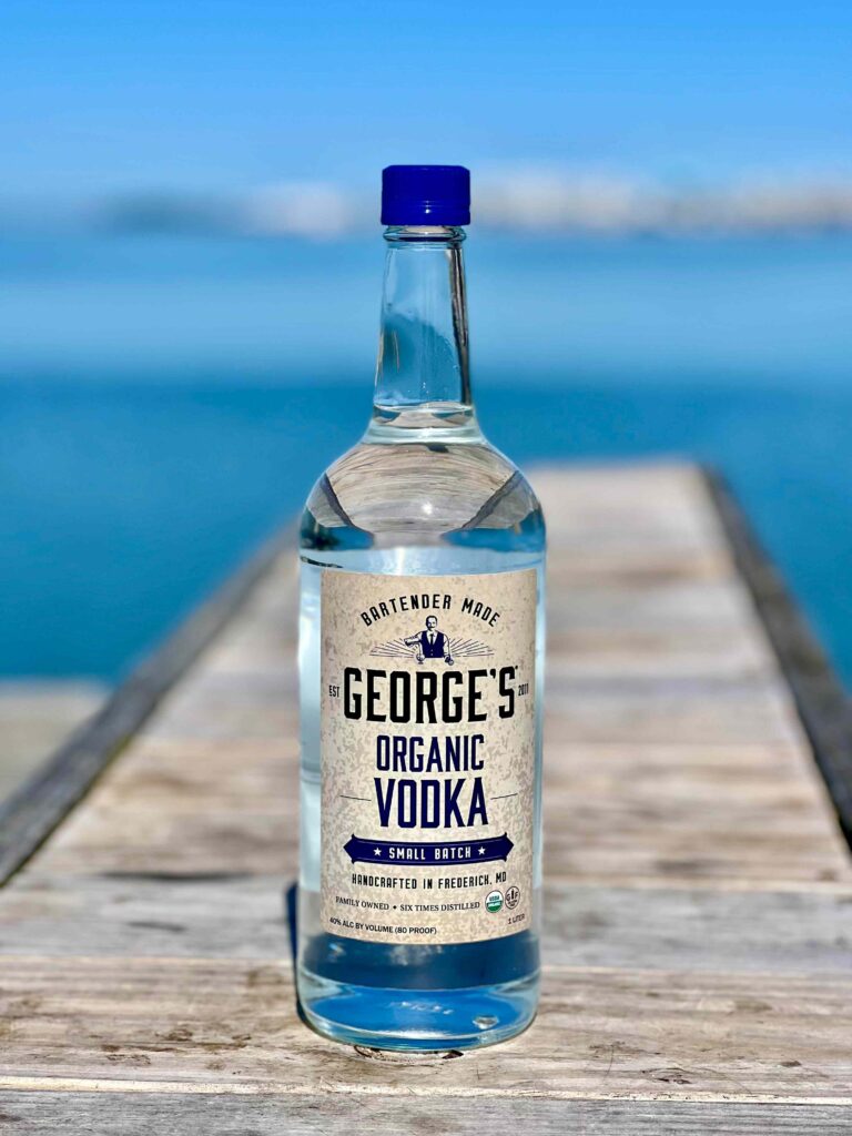 bottle of George's Organic Vodka on pier by water